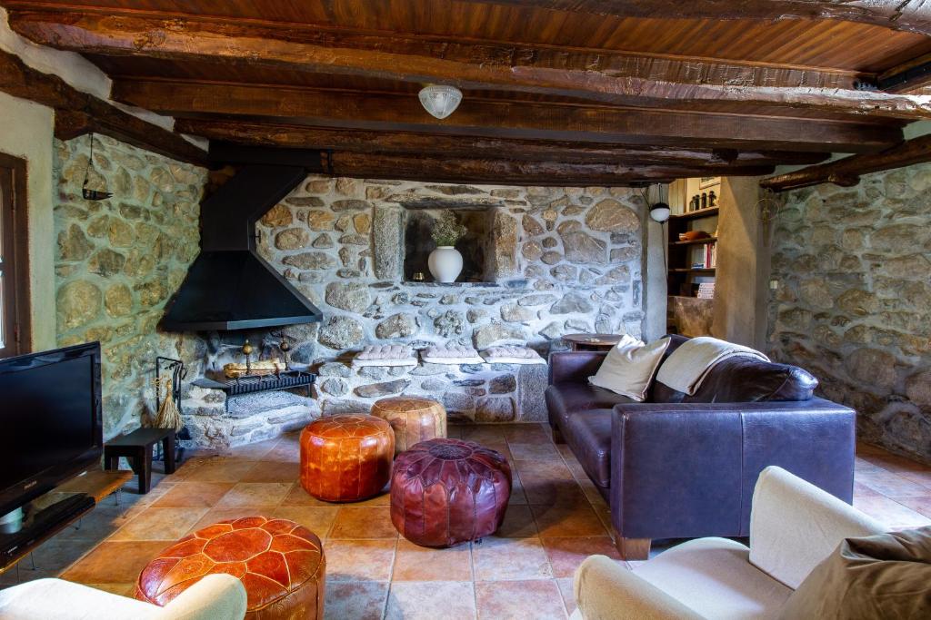 a living room with a couch and a stone wall at Maison en Cerdagne avec belle vue in Enveitg