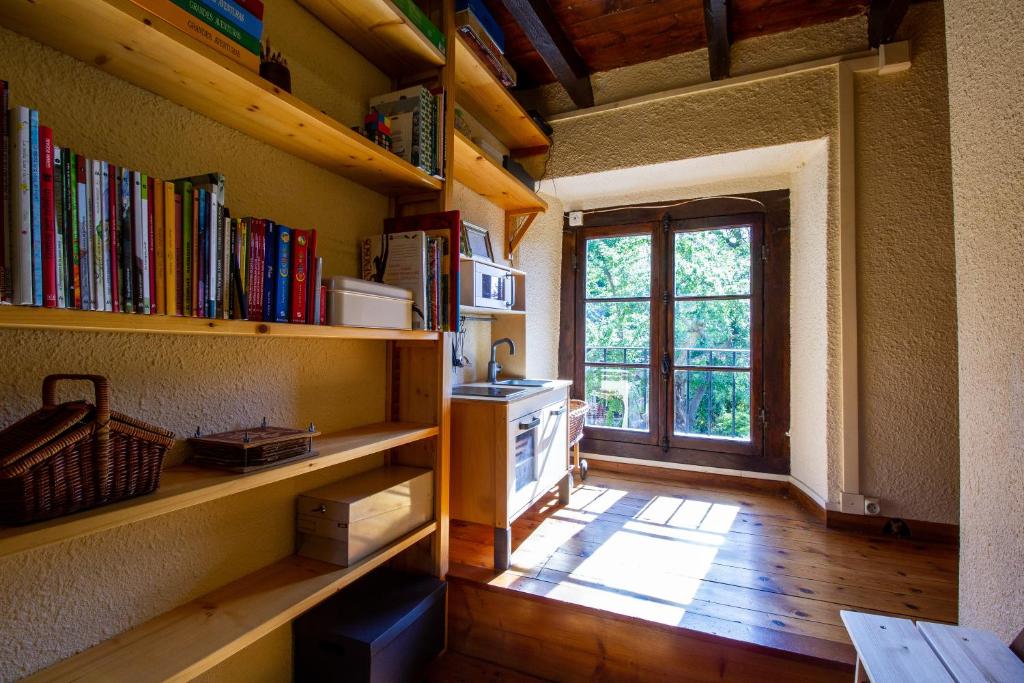 a room with shelves of books and a window at Maison en Cerdagne avec belle vue in Enveitg