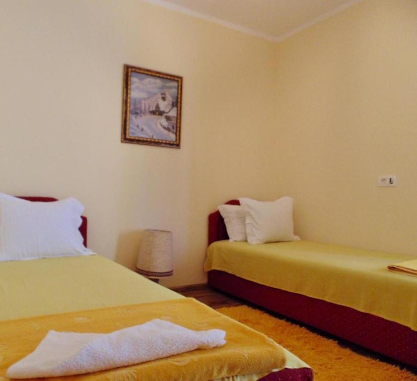 a bedroom with two beds and a picture on the wall at Apartman Rijeka Crnojevica in Rijeka Crnojevića