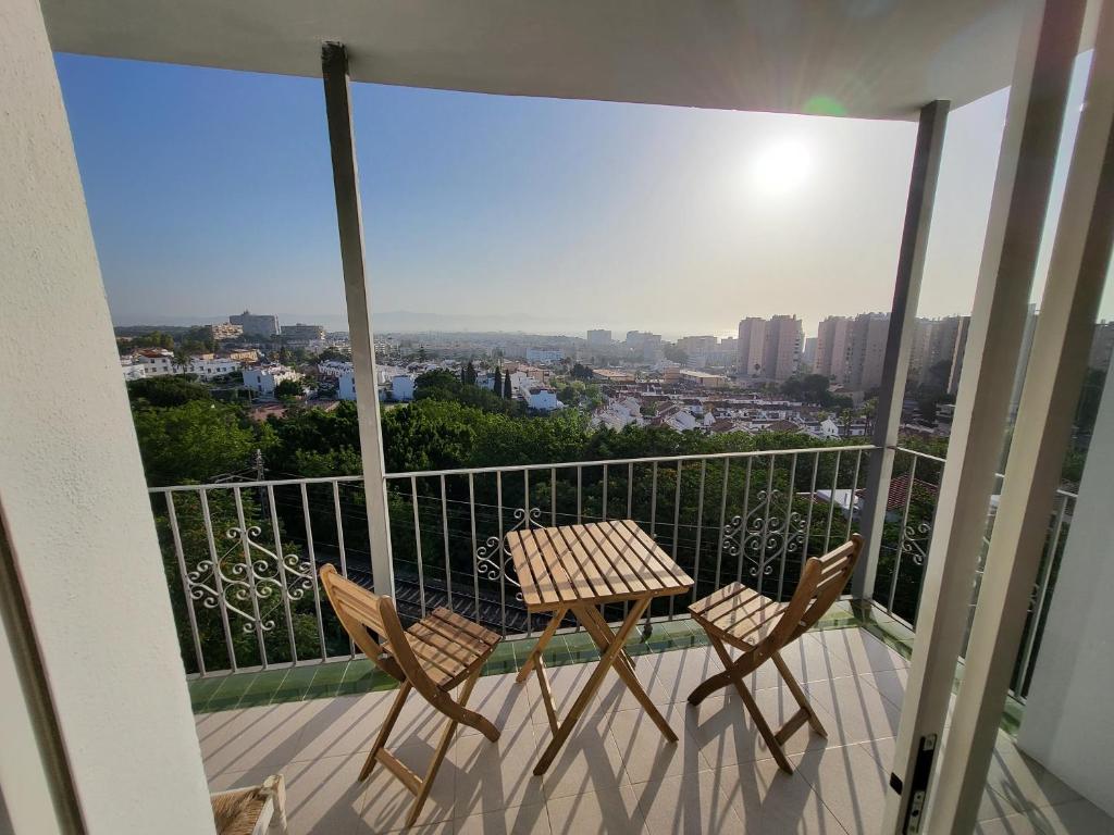 d'une table et de chaises sur un balcon avec vue. dans l'établissement Apt Buenavista en Torremolinos increíbles vistas hacia Málaga 5min del centro y de la playa, à Torremolinos