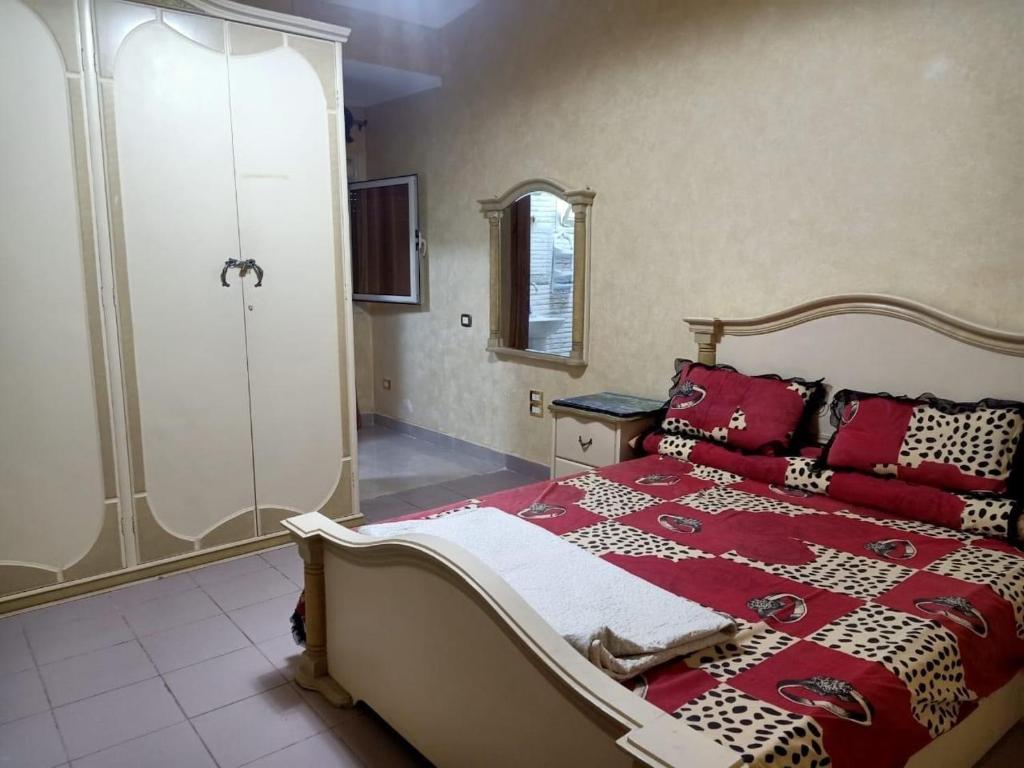 ein Schlafzimmer mit einem großen Bett mit roten Kissen in der Unterkunft الساحل الشمالي in Dawwār Abū Maḩrūs