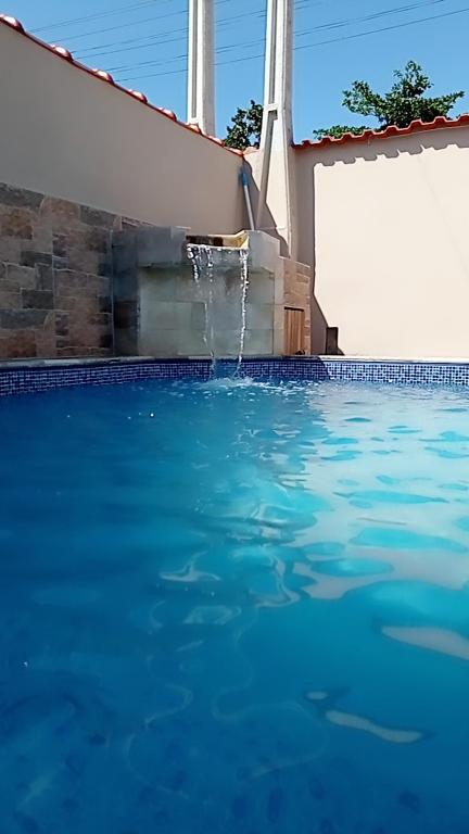 a swimming pool with a water fountain at Casa de praia Melo in Itanhaém