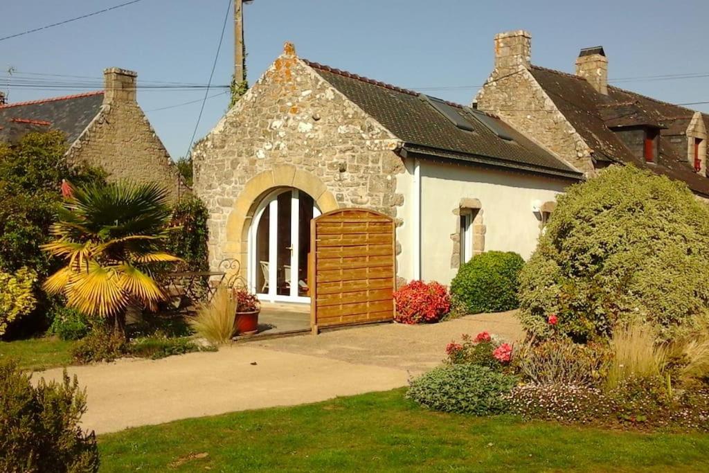 a stone house with a wooden door in a yard at Penty au Ménec in Carnac