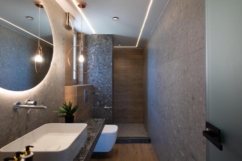 a bathroom with a sink and a toilet and a mirror at Prasonisi Light House Boutique Hotel in Prasonisi