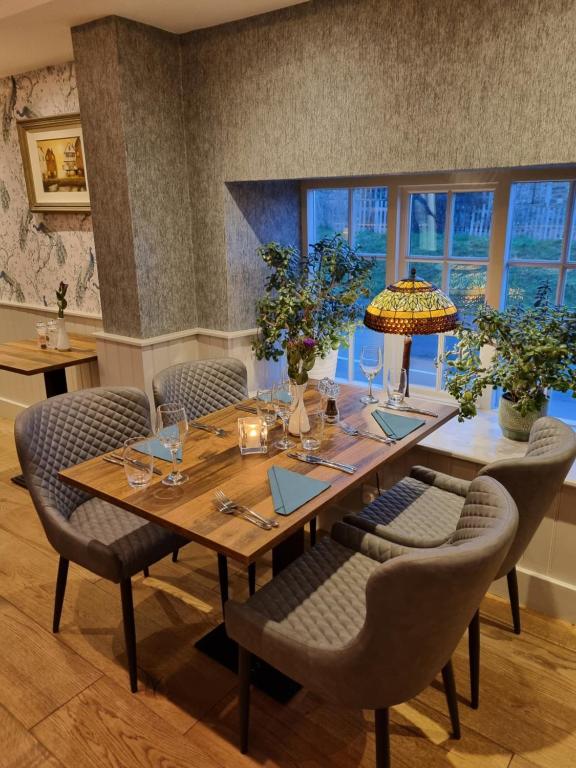ein Esszimmer mit einem Holztisch und Stühlen in der Unterkunft White Horse Inn & Restaurant in Stoke Albany