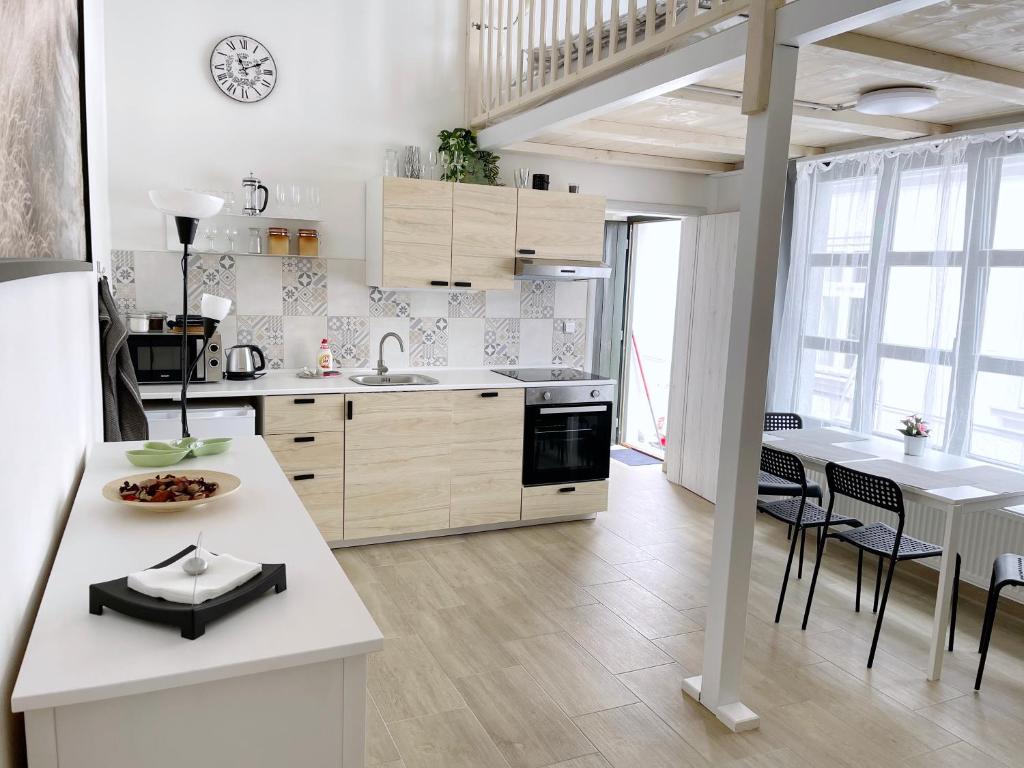 a kitchen with white cabinets and a table and chairs at Comfortable apartments under the St. Barbara´s Cathedral in Kutná Hora