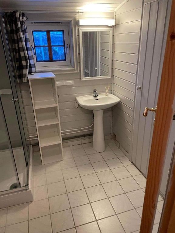 een witte badkamer met een wastafel en een raam bij Hovden in Hovden