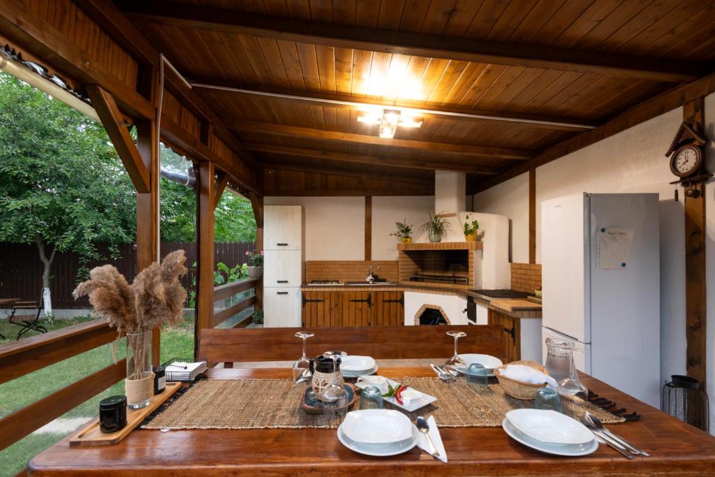 a kitchen with a wooden table with plates on it at Casa lui Matei Murighiol in Murighiol