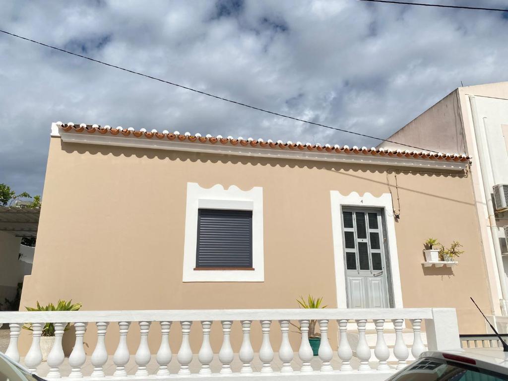 a house with a white fence and a window at Casa da Nespereira in Portimão