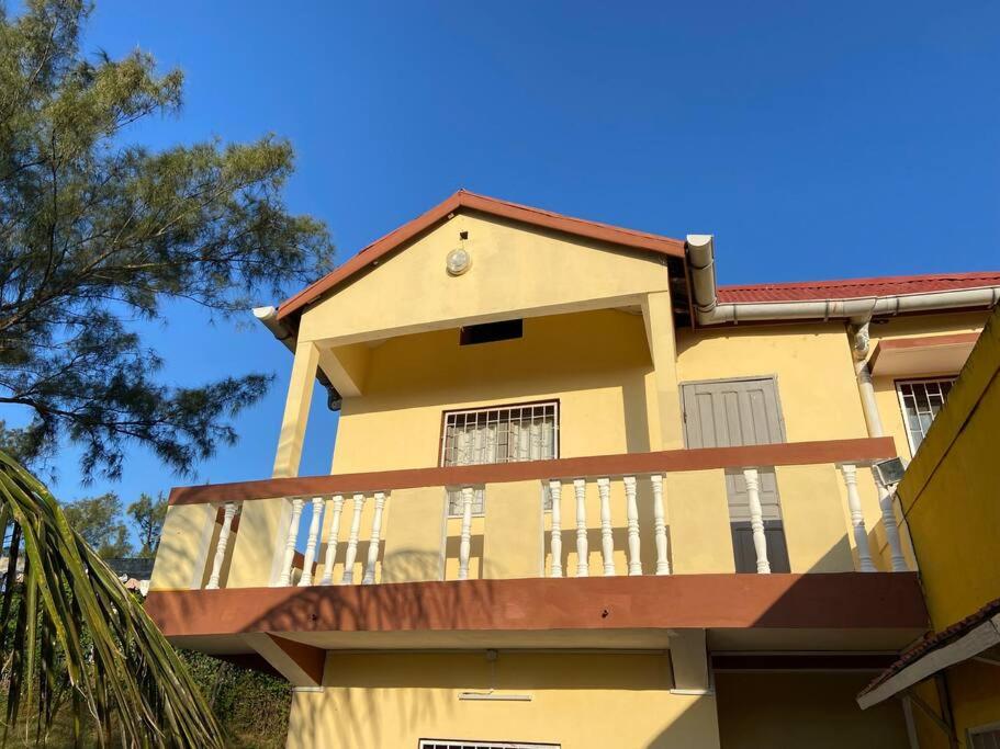 ein gelbes Gebäude mit Balkon darüber in der Unterkunft Appartement indépendant et équipé in Tolagnaro