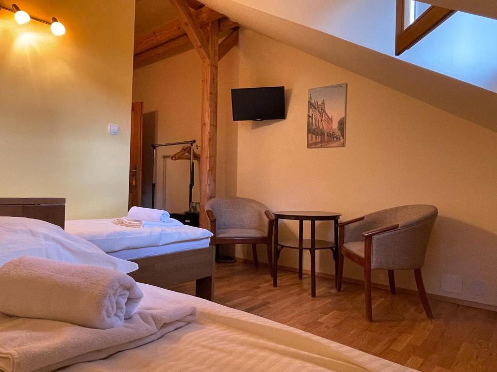 um quarto com duas camas e uma mesa e cadeiras em Ubytovanie u Janusa em Levoča