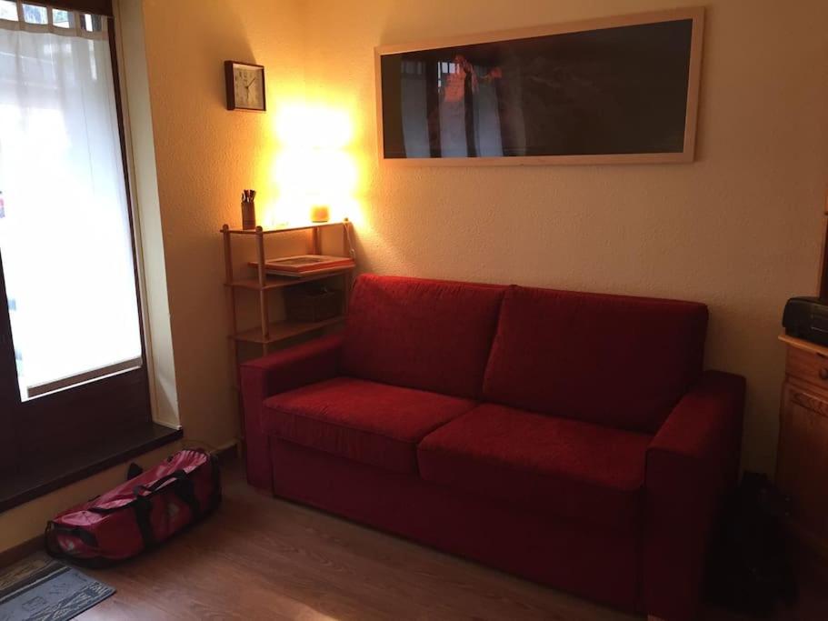 - un salon avec un canapé rouge et une fenêtre dans l'établissement Chamonix centre - 2 pièces 32 m2, à Chamonix-Mont-Blanc