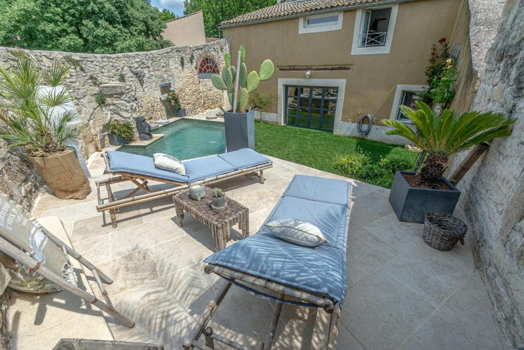 a patio with a pool and a chair and a table at Le Baratier - Demeure de charme Sauna & Piscine in Calvisson