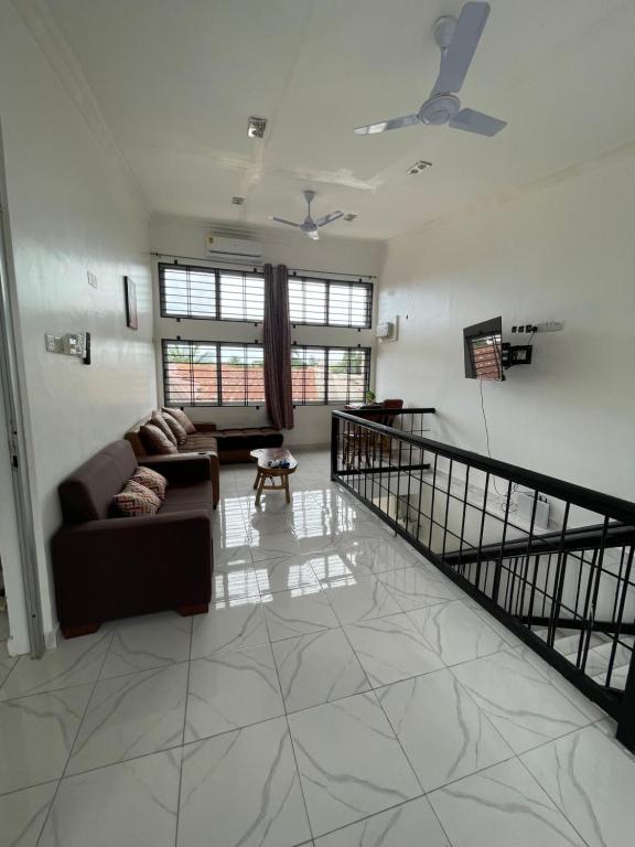 Big & confortable apartment for 6 - Center of Osu La Crescent في آكرا: غرفة معيشة مع أريكة ودرج