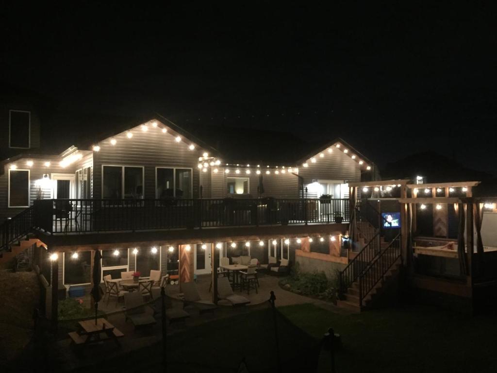 a house with lights on the deck at night at Dragonfly Inn Walkout Suites in Sherwood Park