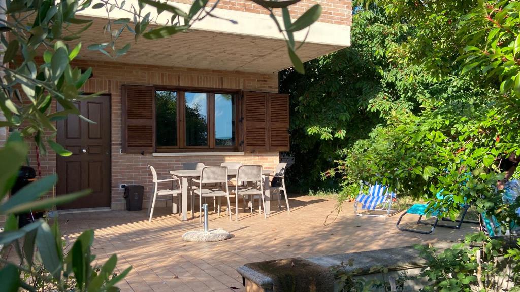 un patio con mesa y sillas frente a una casa en La Casa delle Ciliegie en Asís