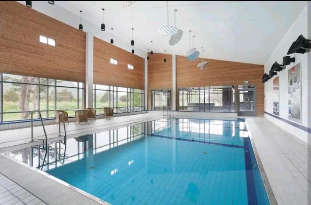 a large swimming pool with blue water in a building at Bøvervegen 19 Appartment nr 9 in Bjorli