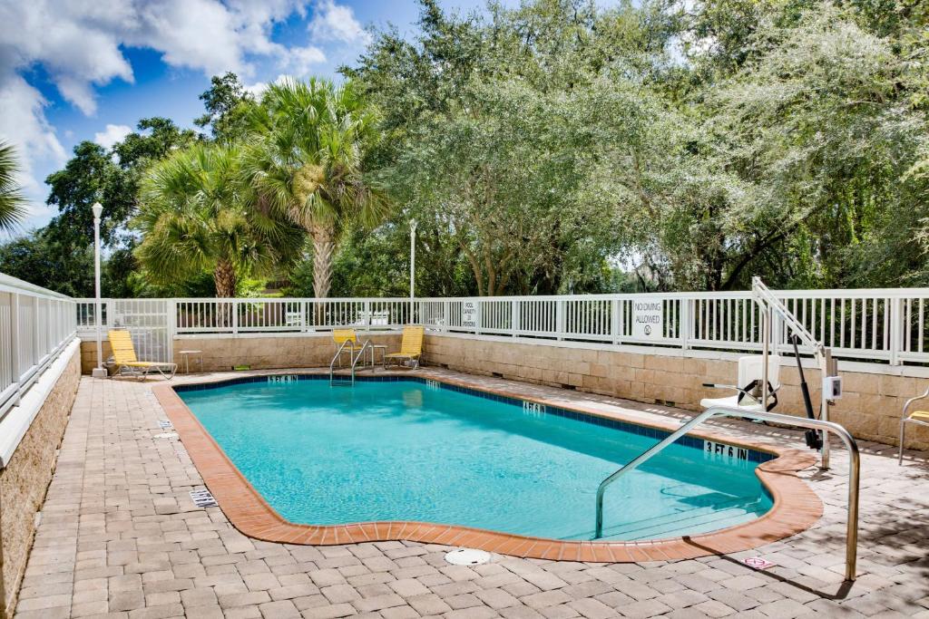 a swimming pool in a yard with a fence at Fairfield by Marriott Inn & Suites Melbourne West/Palm Bay in Melbourne