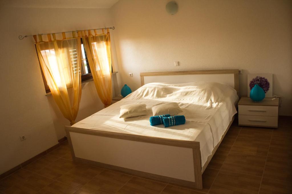 een slaapkamer met een bed met twee handdoeken erop bij Vasto Apartments in Kaštela