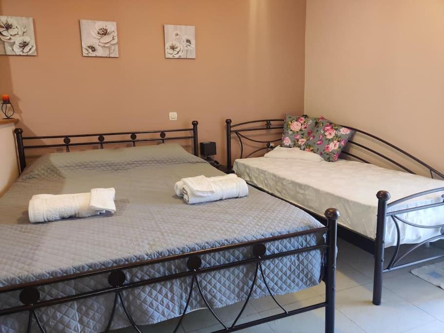 two beds in a room with towels on them at Mixaleas apartments in Kalamata