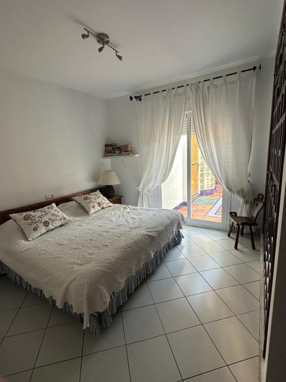 une chambre avec un lit et une grande fenêtre dans l'établissement Costabella / Marbella a mar, à Marbella