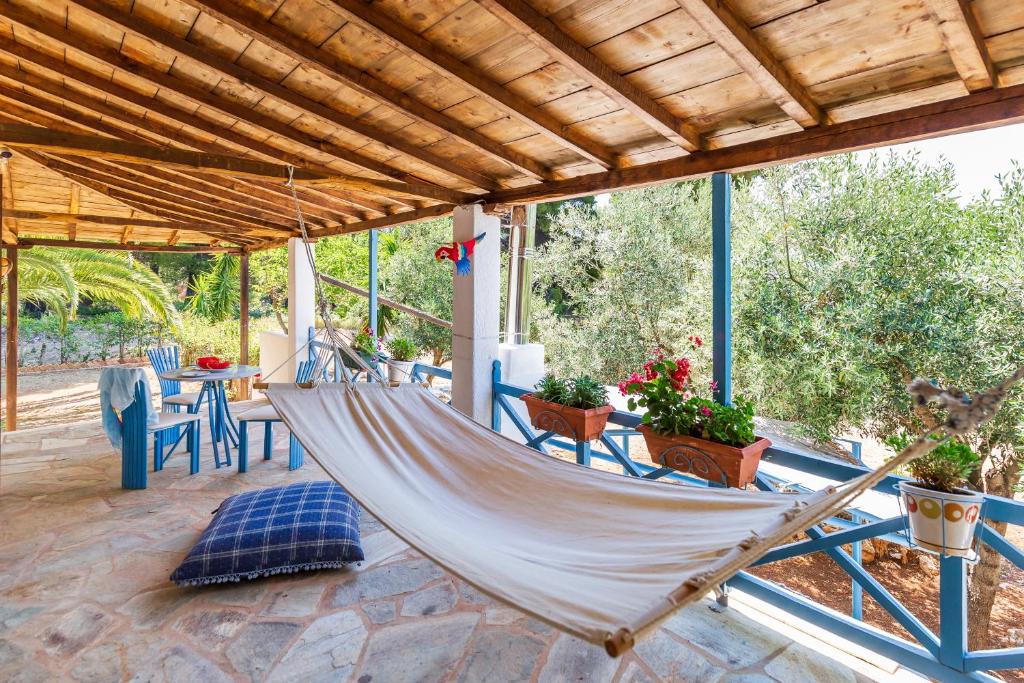 a hammock on a porch of a house at CalmNature in Agnontas