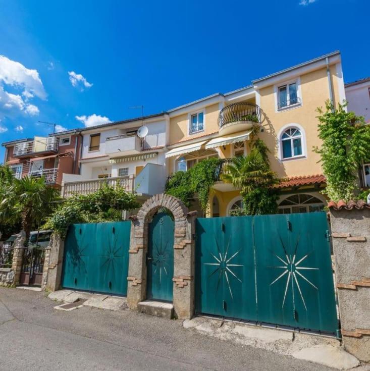 a house with a green gate in front of it at Leonarda in Crikvenica
