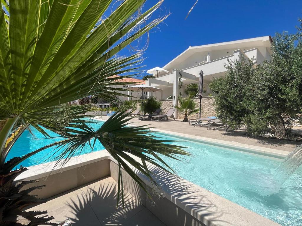 uma villa com uma piscina e uma casa em Apartments and Rooms Mateša em Vodice