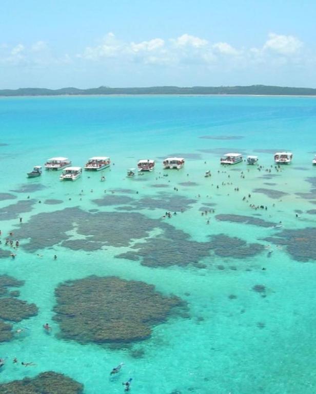 a group of boats in the water in the ocean at Casa de Seu Bandeira in Maragogi