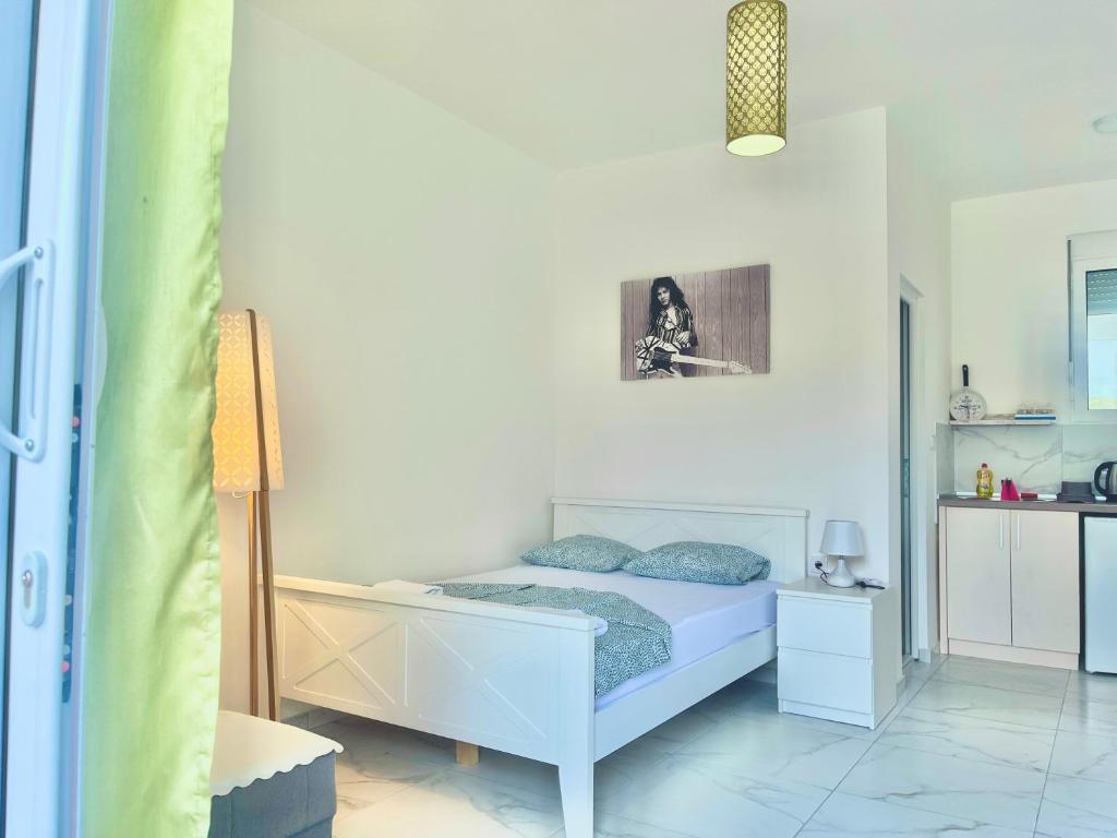 1 dormitorio con 1 cama en una habitación blanca en Apartments Mia Patria, en Ulcinj