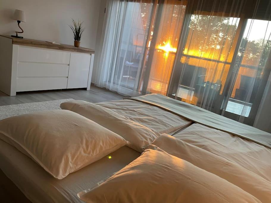 a large bed in a room with large windows at Edisonvilla213 in Fonyód