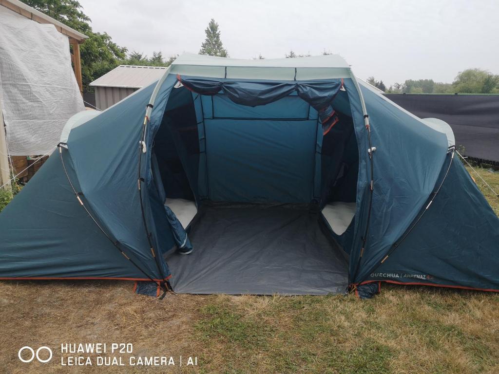 a tent with the door open in a field at tente pour 4 personnes in Saint-Jean-de-Monts