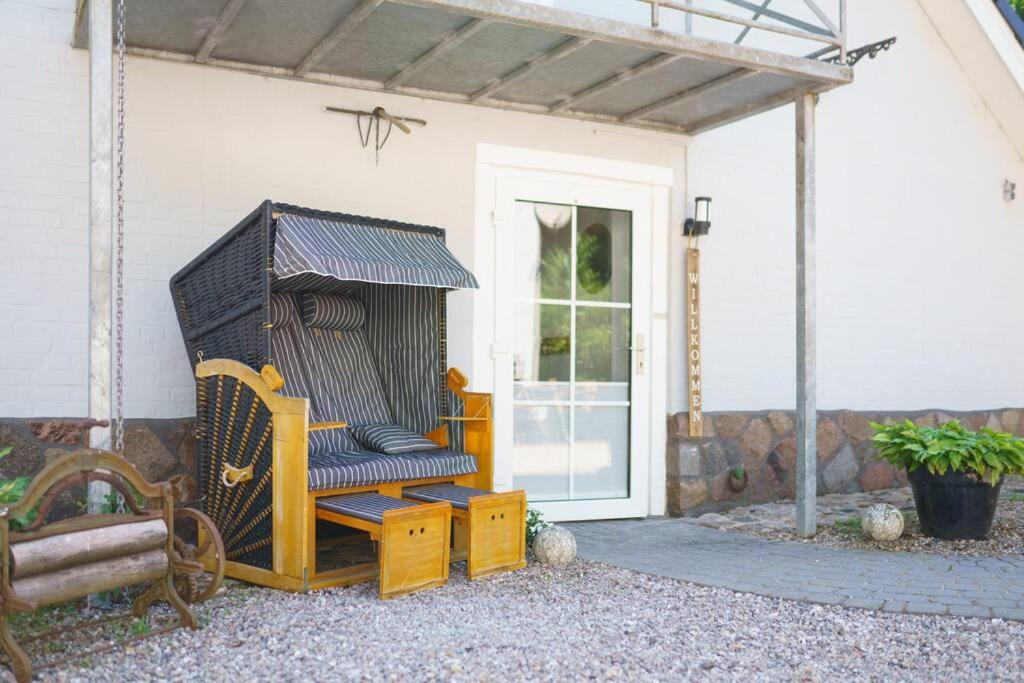 a porch with a wooden bench and a house at Ferienwohnung inmitten der Natur 
