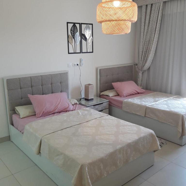 um quarto com 2 camas e um lustre em شالية بمراسي فرش فندقي السعر شامل الكروت em El Alamein