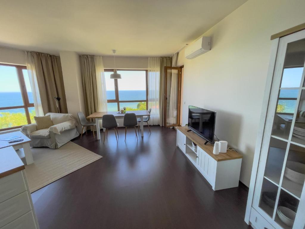 a living room with a couch and a table with a television at Cabacum Beach Residence AP.19 in Varna City