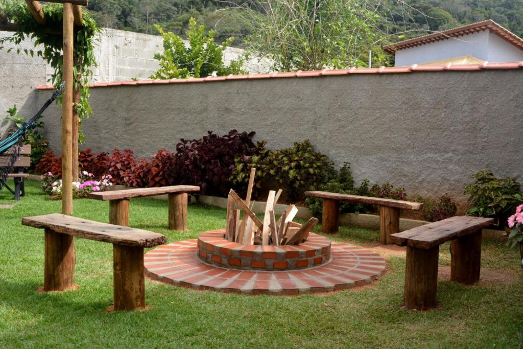 a park with two benches and a fire pit at Cantinho Bebler in Santa Teresa