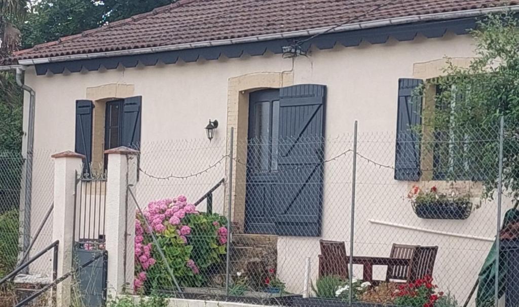 a white house with black doors and flowers at Le Moulin in Bassoues