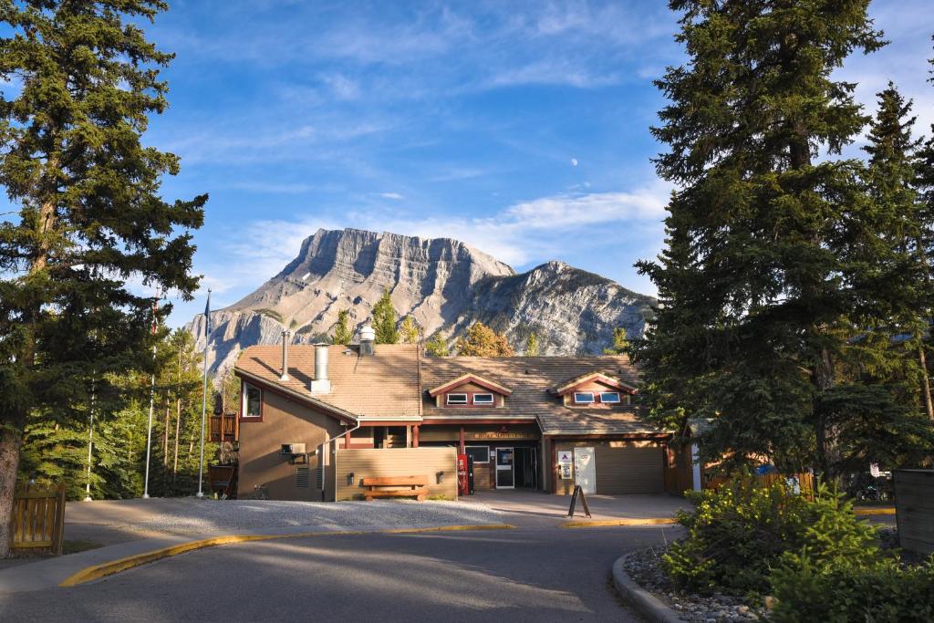 una casa con una montaña en el fondo en HI Banff Alpine Centre - Hostel, en Banff