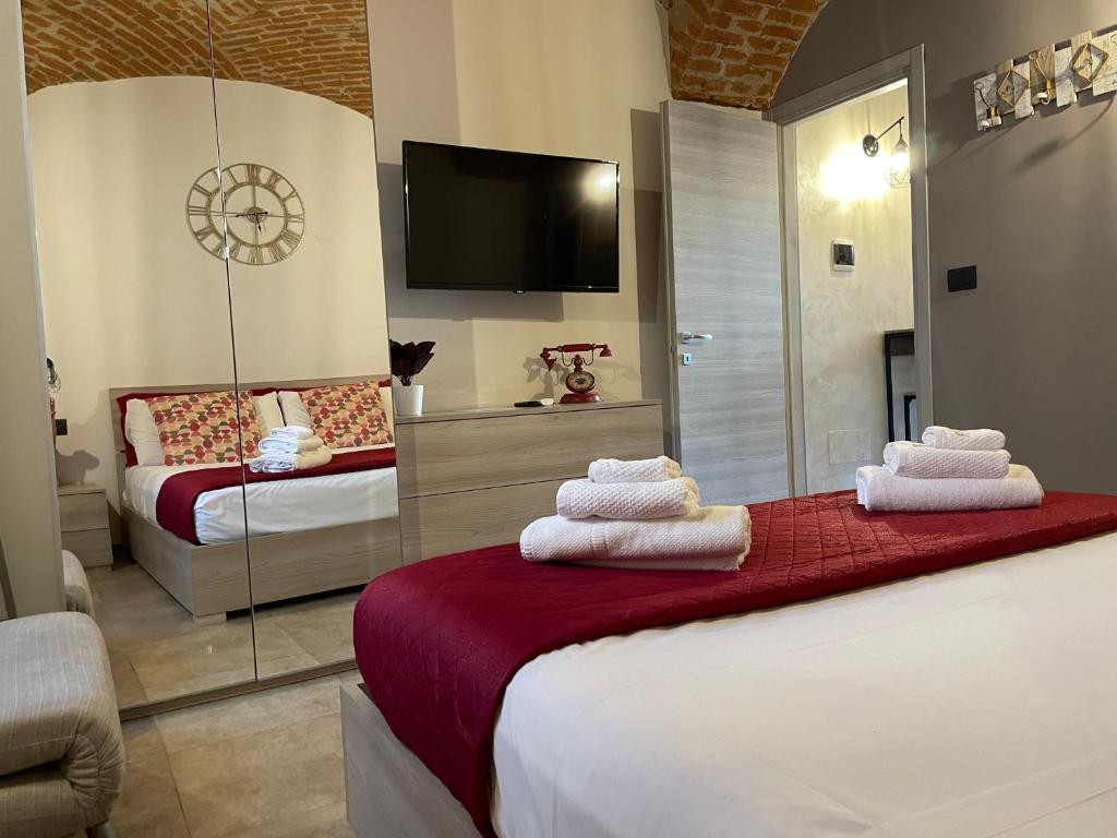 a hotel room with two beds and a tv at HappyHome Bilocale centro storico Rivarolo Canavese in Rivarolo Canavese