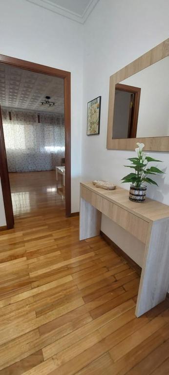 a living room with a table and a mirror at Piso Ribeira Sacra in Monforte de Lemos