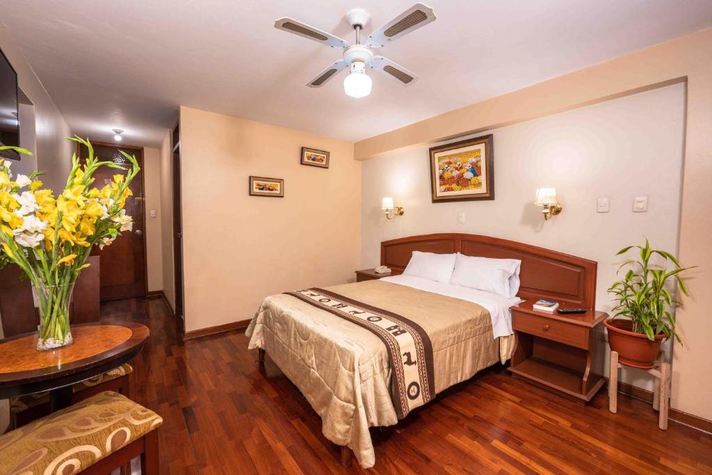 Hotel Manhattan Inn Airport في ليما: غرفة الفندق بسرير وطاولة