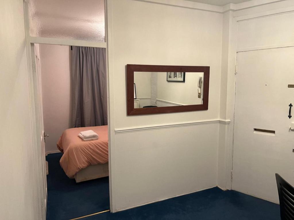 um quarto com uma cama e um espelho na parede em 2 large bedroom apartment in central London em Londres