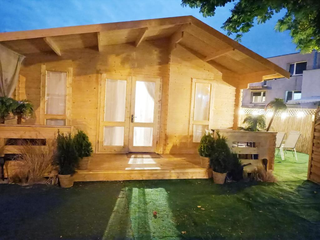 uma pequena casa de madeira com uma porta grande em Dreamholia em Jastarnia