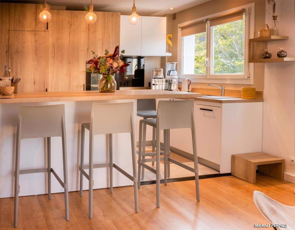 a kitchen with a island with bar stools at RÉF 218 - PLOEMEUR Très beau type 2 bien agencé et équipé en hyper centre in Ploemeur