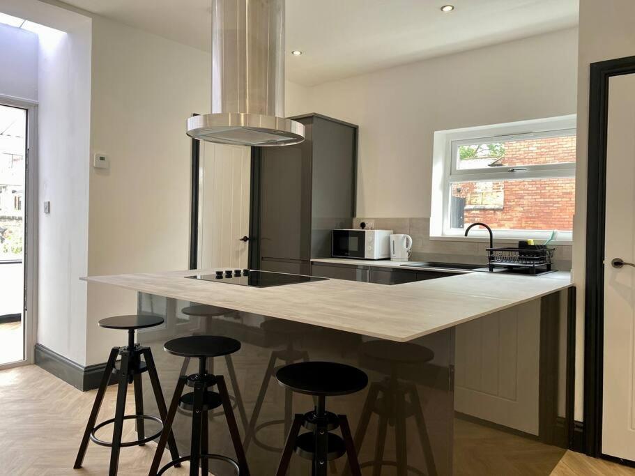 a kitchen with a island with bar stools at 3 bed house Hyde near Manchester in Hyde