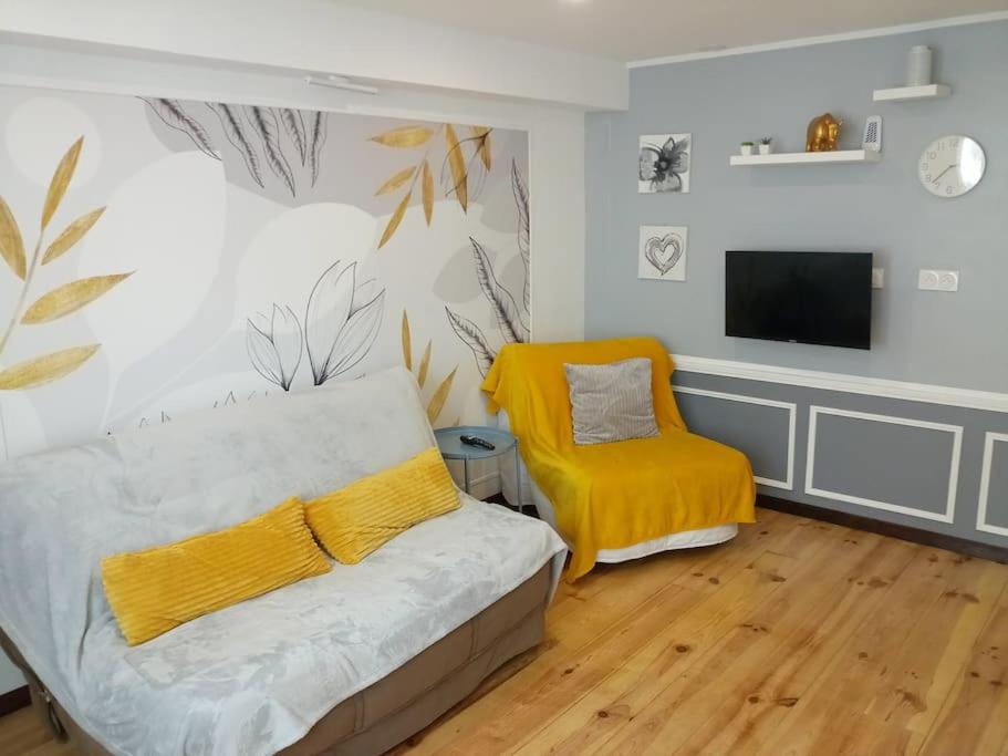 ein Schlafzimmer mit einem Bett und einem gelben Stuhl in der Unterkunft Cosy petit appartement in Gignac