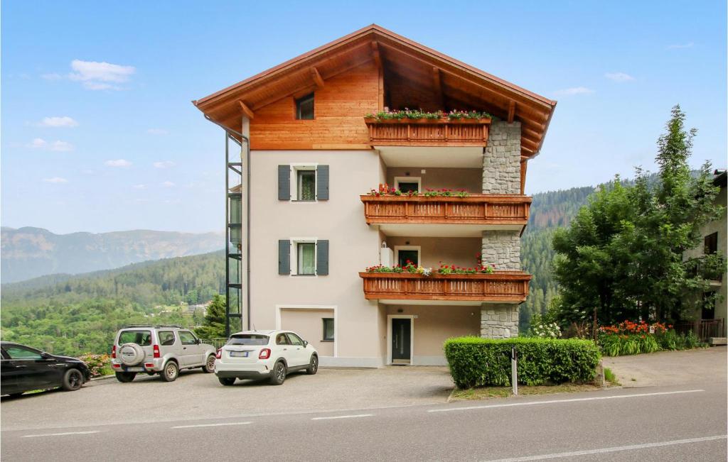a building with balconies and cars parked in a parking lot at Amazing Apartment In Mezzana With Wifi in Mezzana