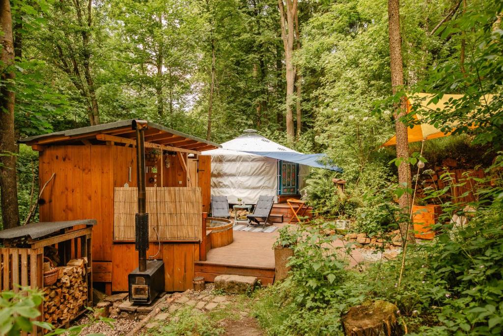 a wooden cabin in the woods with a tent at Yurt in the Wood 