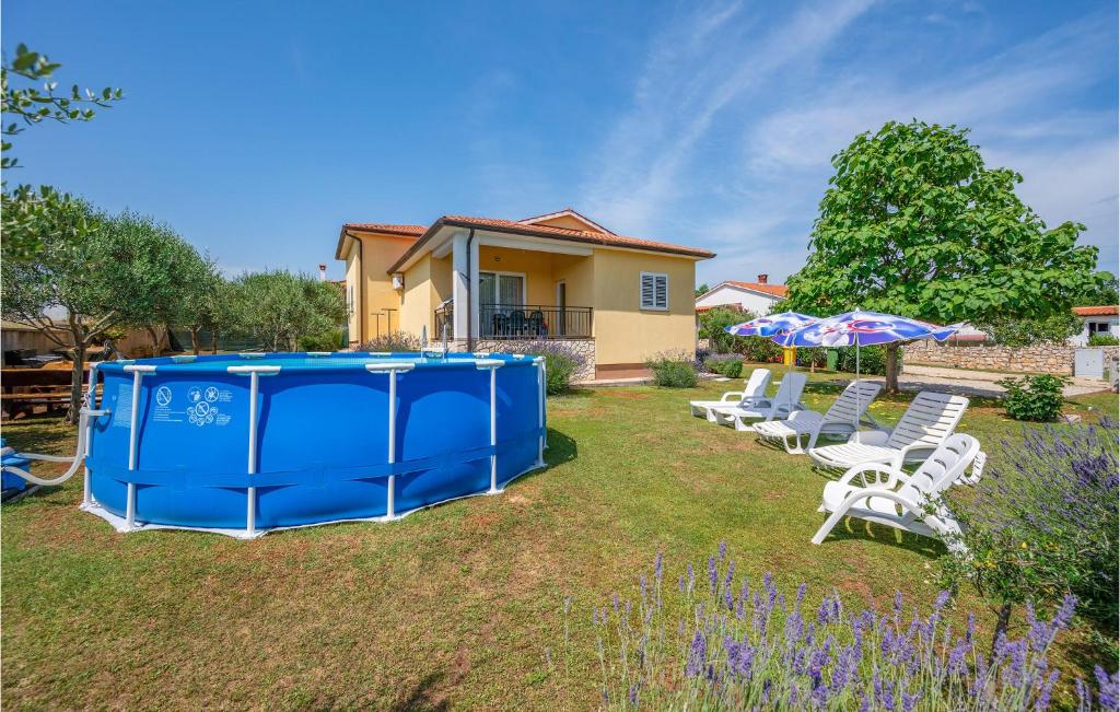 a group of chairs and umbrellas in a yard at Cozy Home In Nedescina With Kitchen in Nedeščina