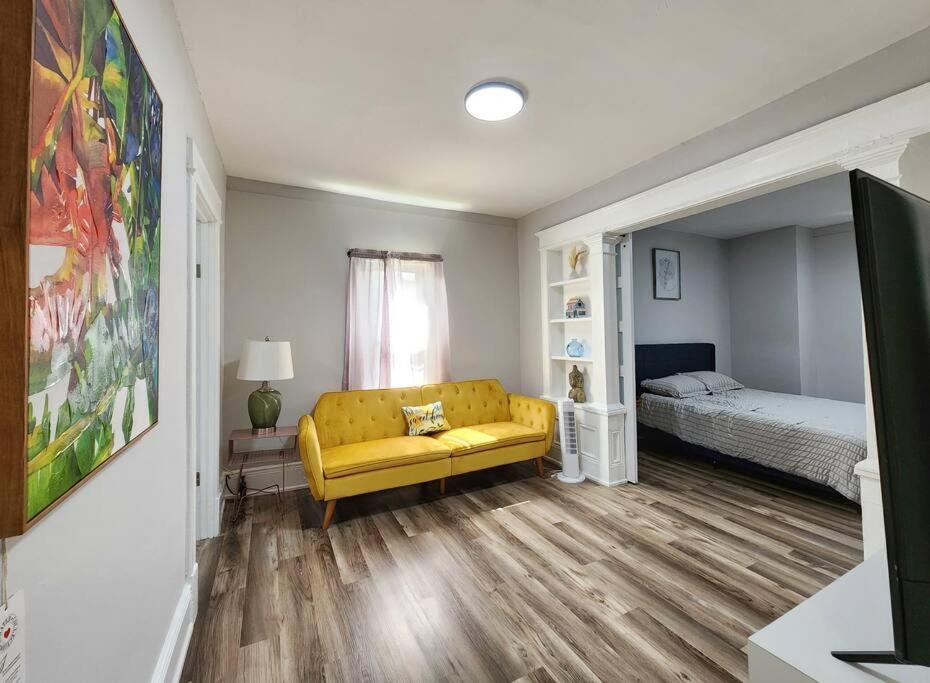 ein Wohnzimmer mit einem gelben Sofa und einem Bett in der Unterkunft Tastefully furnished repose home in Springfield